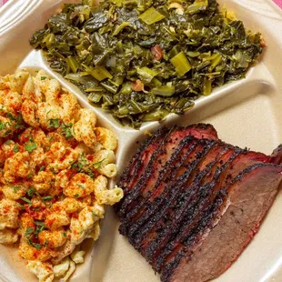 Brisket plate with pasta salad and collard greens.