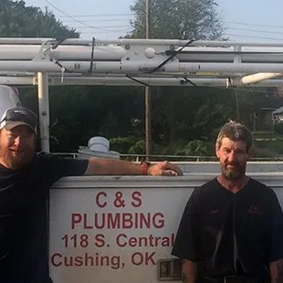 four men standing in front of a truck