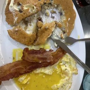 Half cooked Blueberry Pancake, runny eggs and bacon