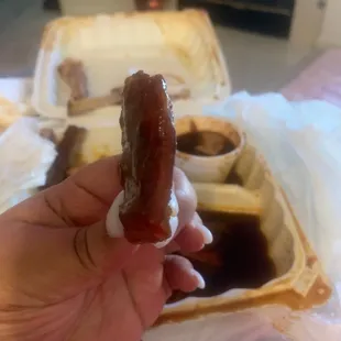 a hand holding a hot dog