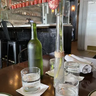  glass of water and a bottle on a table