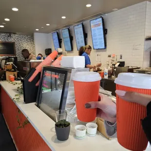 ows a counter with cups of coffee