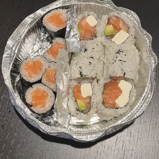 a plate of sushi with salmon and avocado