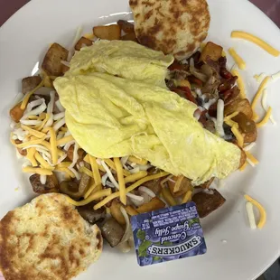 ultimate mess, potatoes topped with onions, peppers, mushrooms, bacon, sausage, ham, shredded cheese and eggs