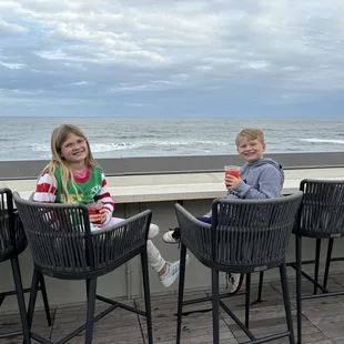 Children enjoying a smoothie overlooking the water at the rooftop