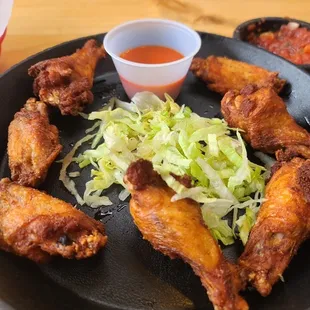 a plate of fried chicken wings with a side of ketchup