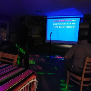 a man sitting in front of a projection screen