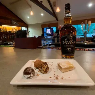 a plate of donuts and a bottle of whiskey