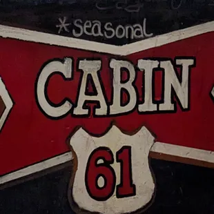 a red and white sign on a black wall