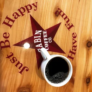 a cup of coffee on a wooden table