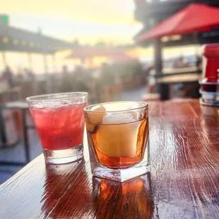 two glasses of alcohol on a wooden table