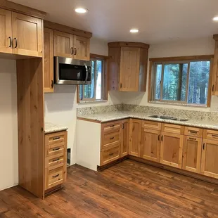 a kitchen with wood floors and cabinets
