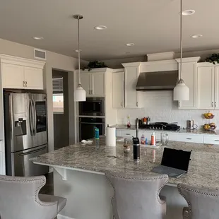 a kitchen with white cabinets and granite countertops