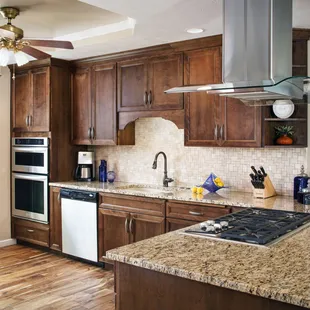 Koch Cabinets with a stainless/glass island hood and built in oven