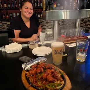 a woman sitting at a table with a plate of food
