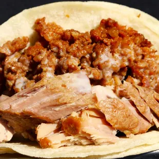 a close up of a taco with meat and beans
