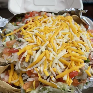 Nachos (lettuce, tomato, Mexican rice, refried beans, pico de gallo and not showing the white Queso  sauce)