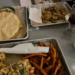 Fried pickles, sweet potato fries, chicken sandwich, and hummus with popodam (sp?)
