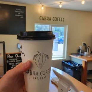 a hand holding a cup of coffee