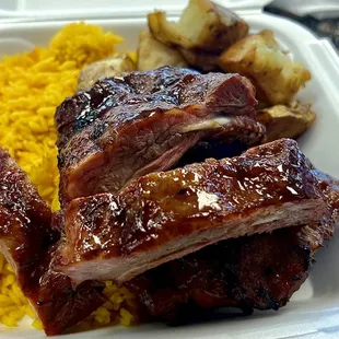 Baby back, ribs, yellow rice, and roasted potatoes.