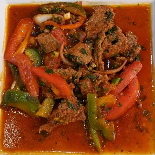 a plate of beef and peppers