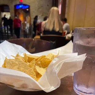 a bowl of chips and a glass of water