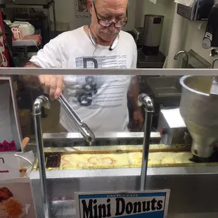 a man making donuts in a donut shop
