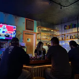people sitting at a bar watching a baseball game