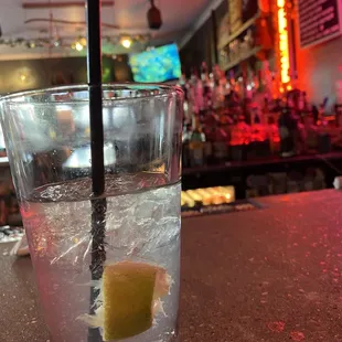 a glass of water with a lemon wedge in it
