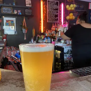 a glass of beer on a bar counter