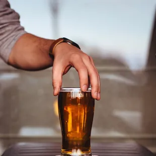 a person holding a glass of beer