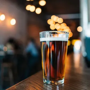 a glass of beer on a bar