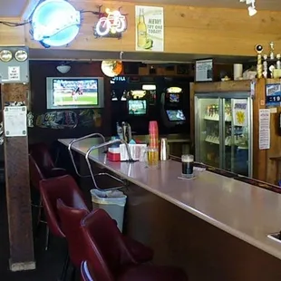 a bar with red chairs