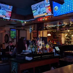 a bar with tvs above the bar