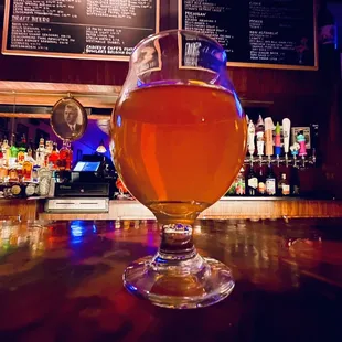 a glass of beer on a bar