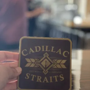 a hand holding a coaster