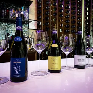 a row of wine glasses and bottles