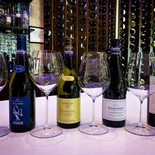 a row of wine glasses and bottles