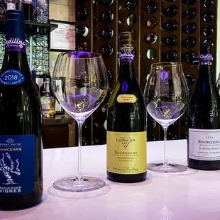 a row of wine glasses and bottles