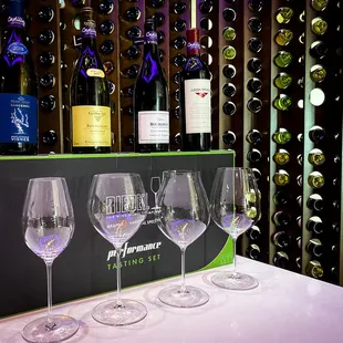 a row of wine glasses in front of a wine rack