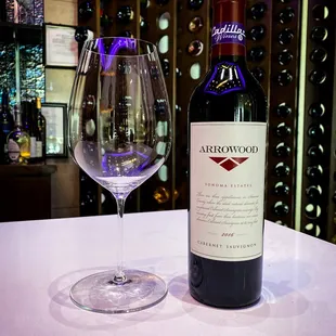 a wine glass and bottle on a table