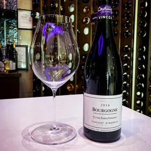 a wine glass and a bottle on a table