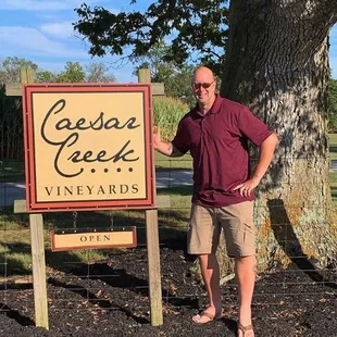 a man standing next to a sign