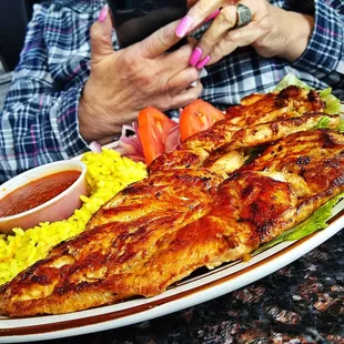 a woman taking a picture of her plate of food