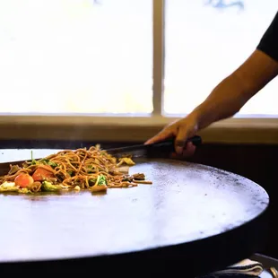 ows a person cutting up food on a table