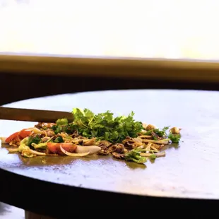 ows a pizza on a table with a knife