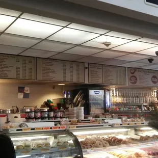 the interior of a cafe with a variety of pastries