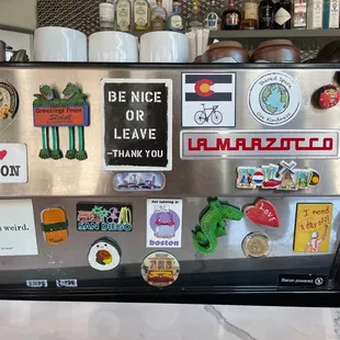 a refrigerator covered in stickers and magnets