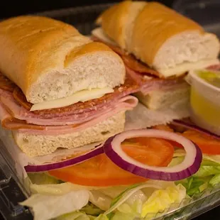 a plate of sandwiches with lettuce, tomato, and ham