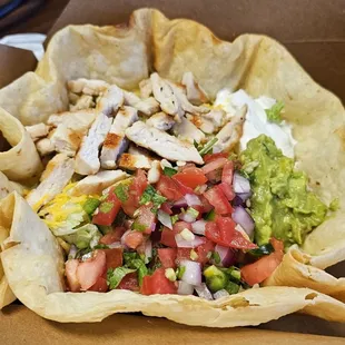 a taco salad in a paper bowl
